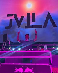 a dj in front of a large screen with the word jila