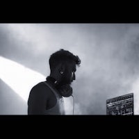 a black and white photo of a dj in front of a laptop