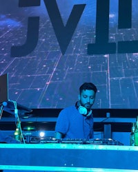 a dj in front of a large screen